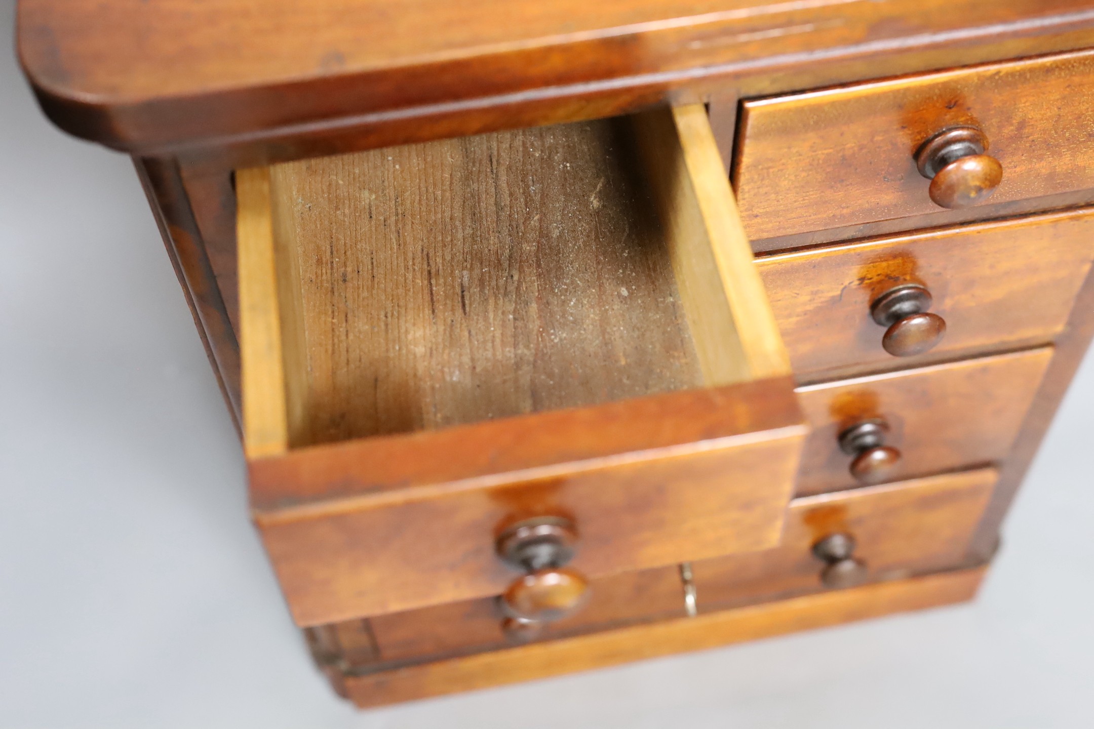 A Victorian miniature chest with five drawers and a key, 38cm tall